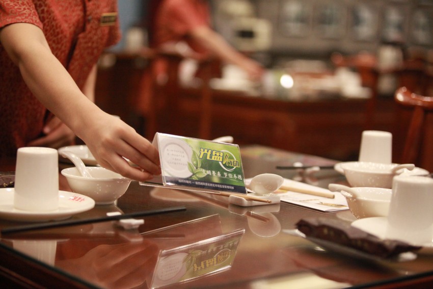 Staff at a local restaurant put up signs with characters saying "Clean Plate Campaign" to urge people against food waste, Yangzhou city, east China's Jiangsu province.